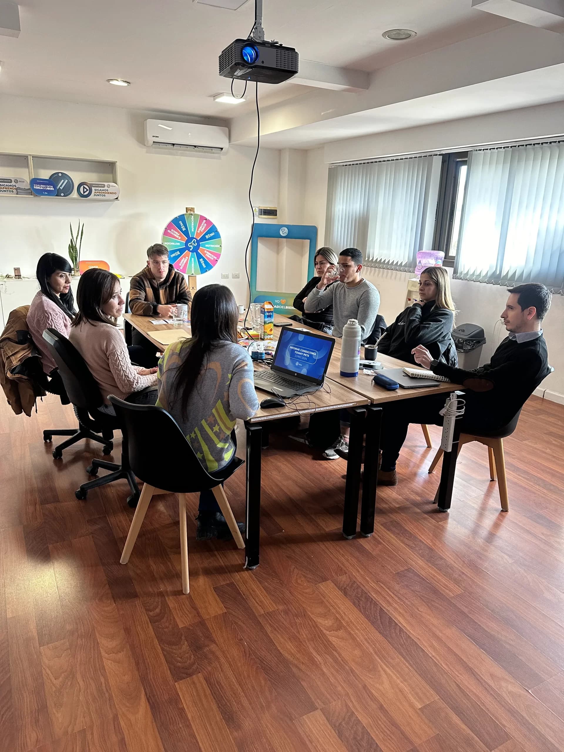 Equipo de BS360 reunido alrededor de una mesa de trabajo